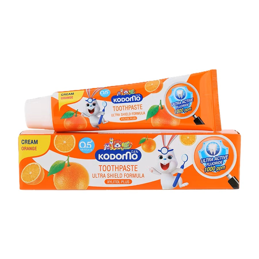 Kodomo Ultra Shield Formula Orange Cream Toothpaste for kids, showing the tube and box with cartoon rabbit, orange slices, and fluoride protection label.