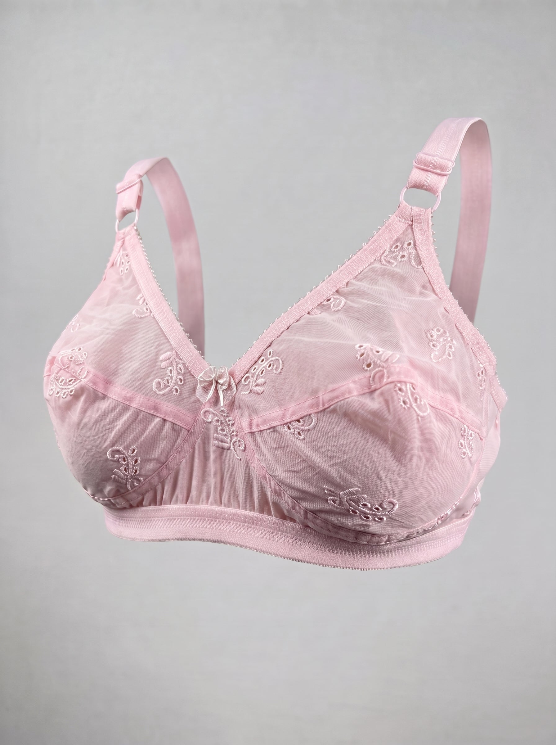 A light pink lace and mesh underwire bra with adjustable shoulder straps, displayed against a neutral gray background. #color_pink