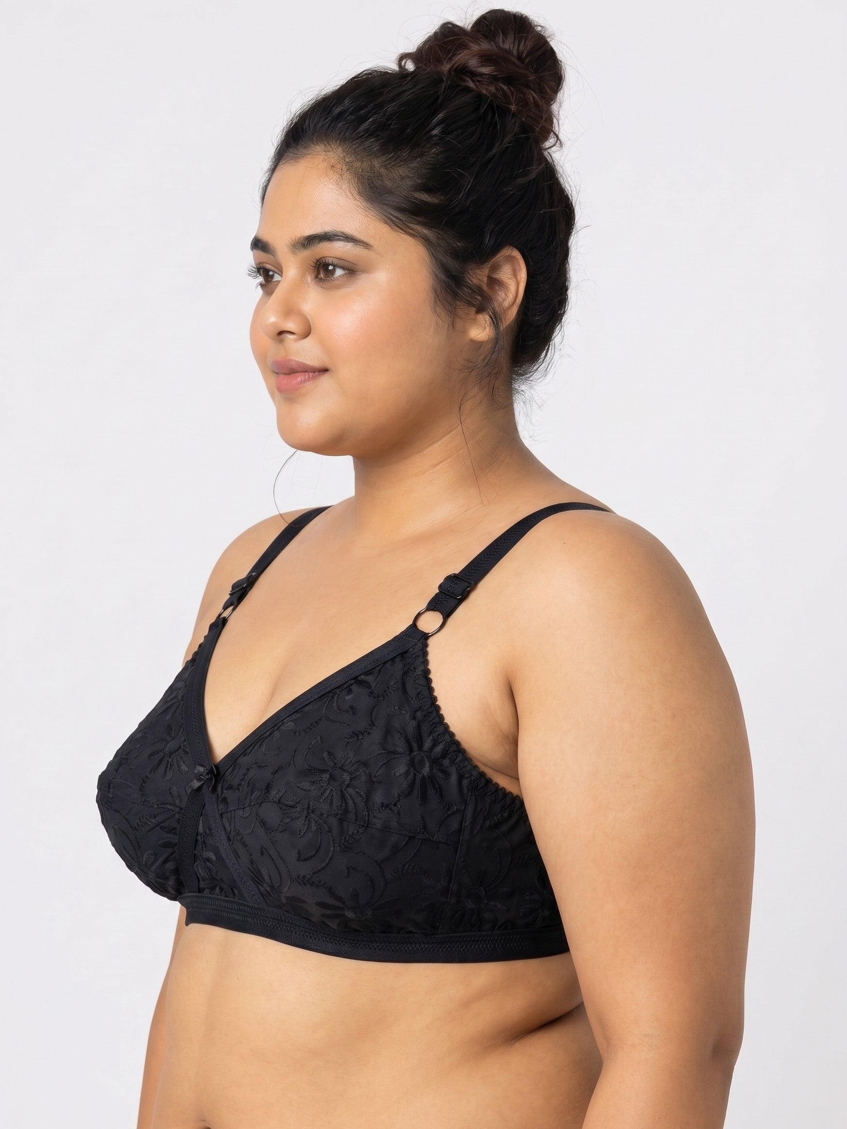 Woman wearing a black lace bralette against a white background #color_black