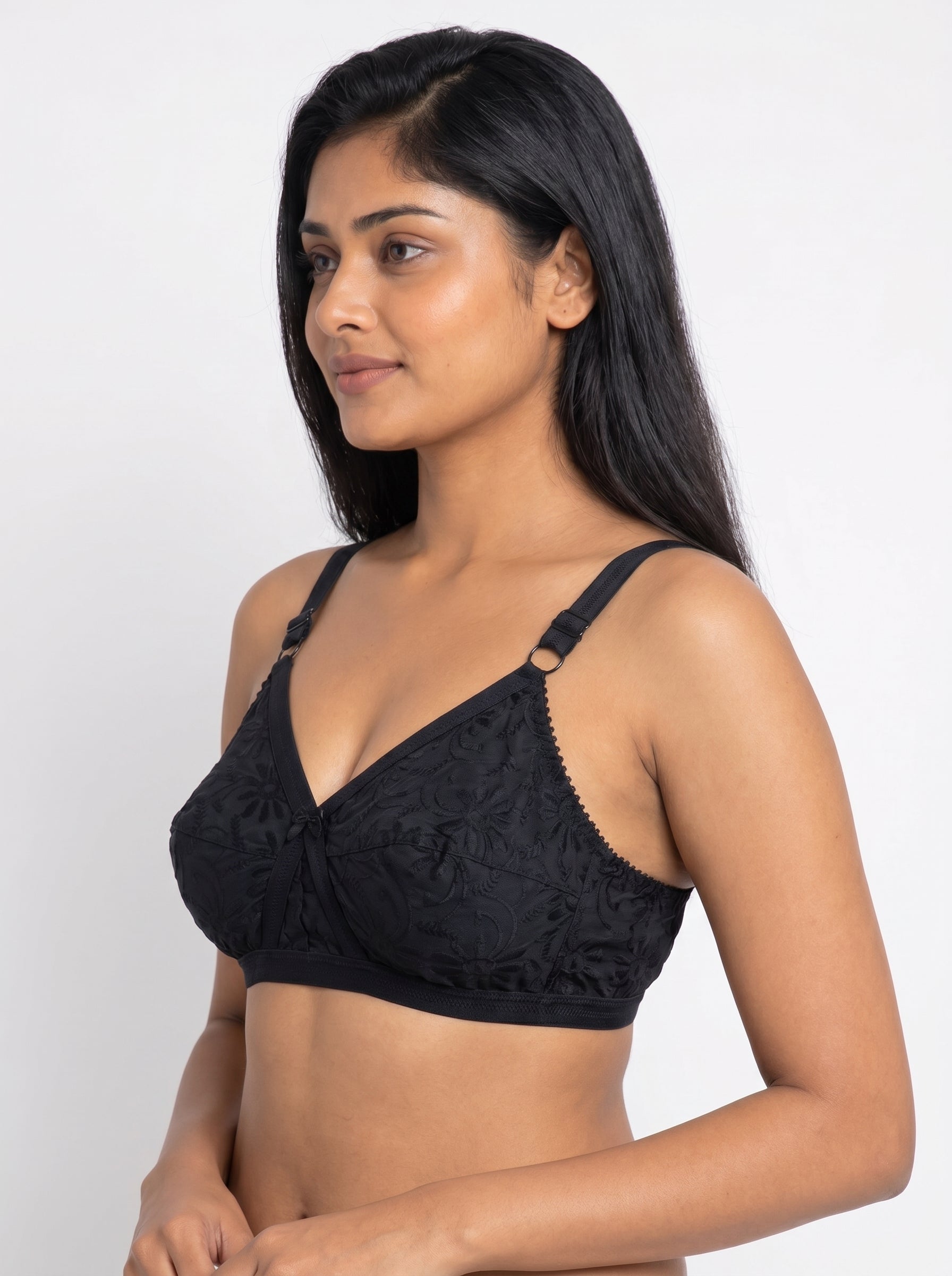 Woman wearing a black lace bralette against a white background #color_black