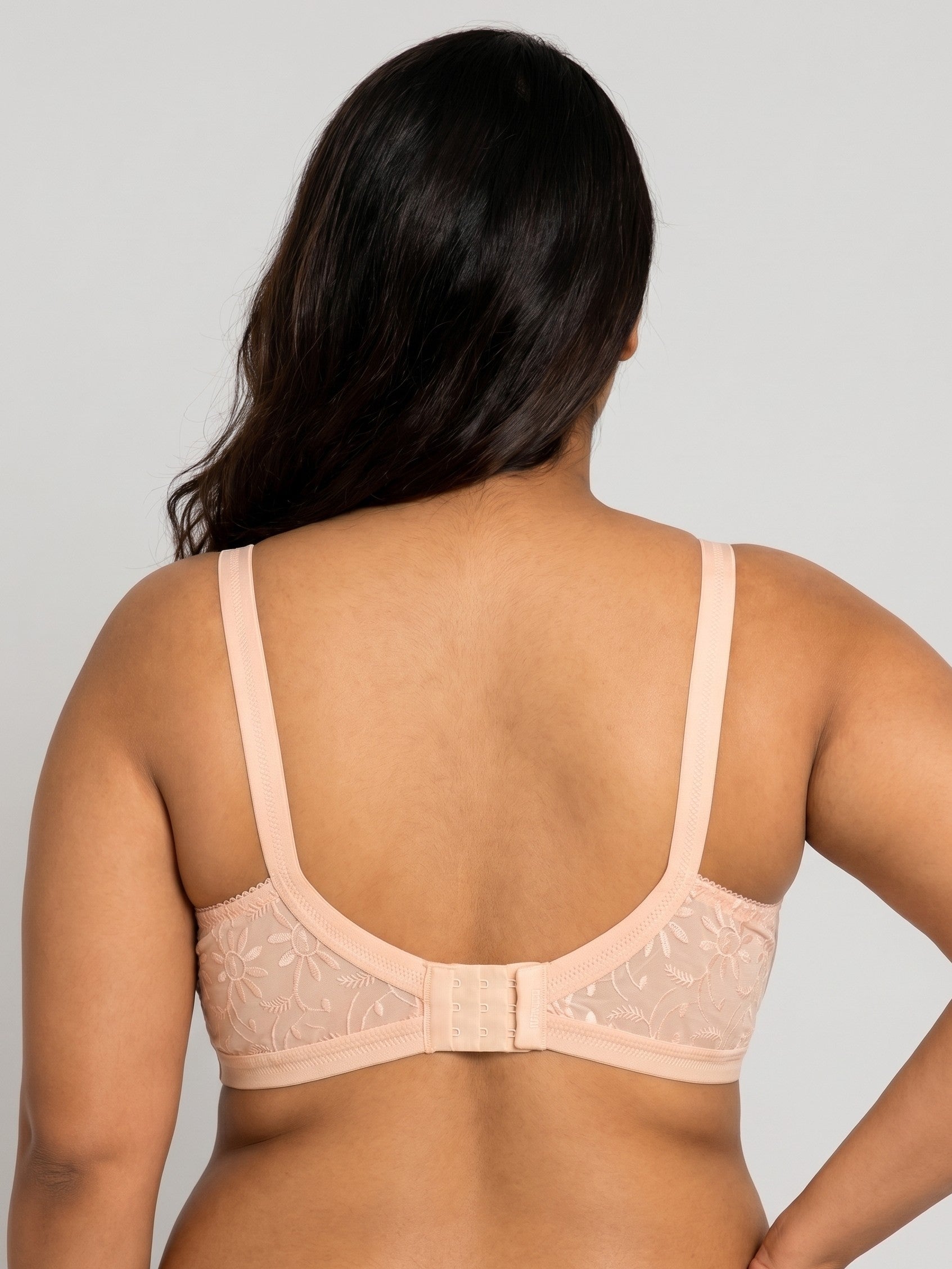 Woman wearing a beige bra against a plain background #color_peach