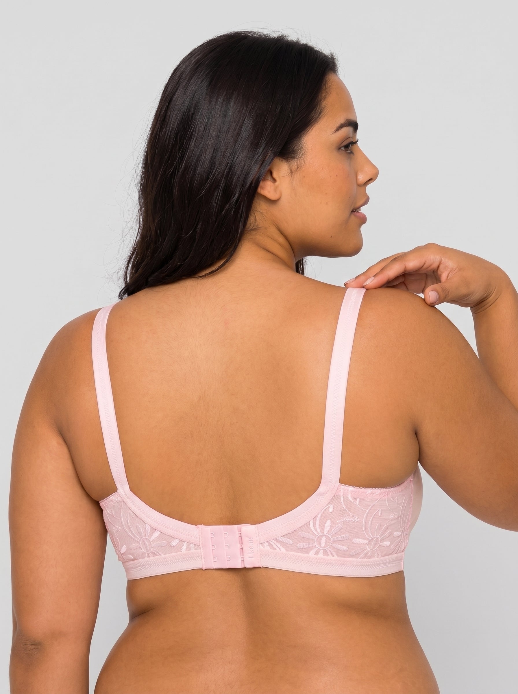 Woman wearing a pink bralette against a plain background #color_pink