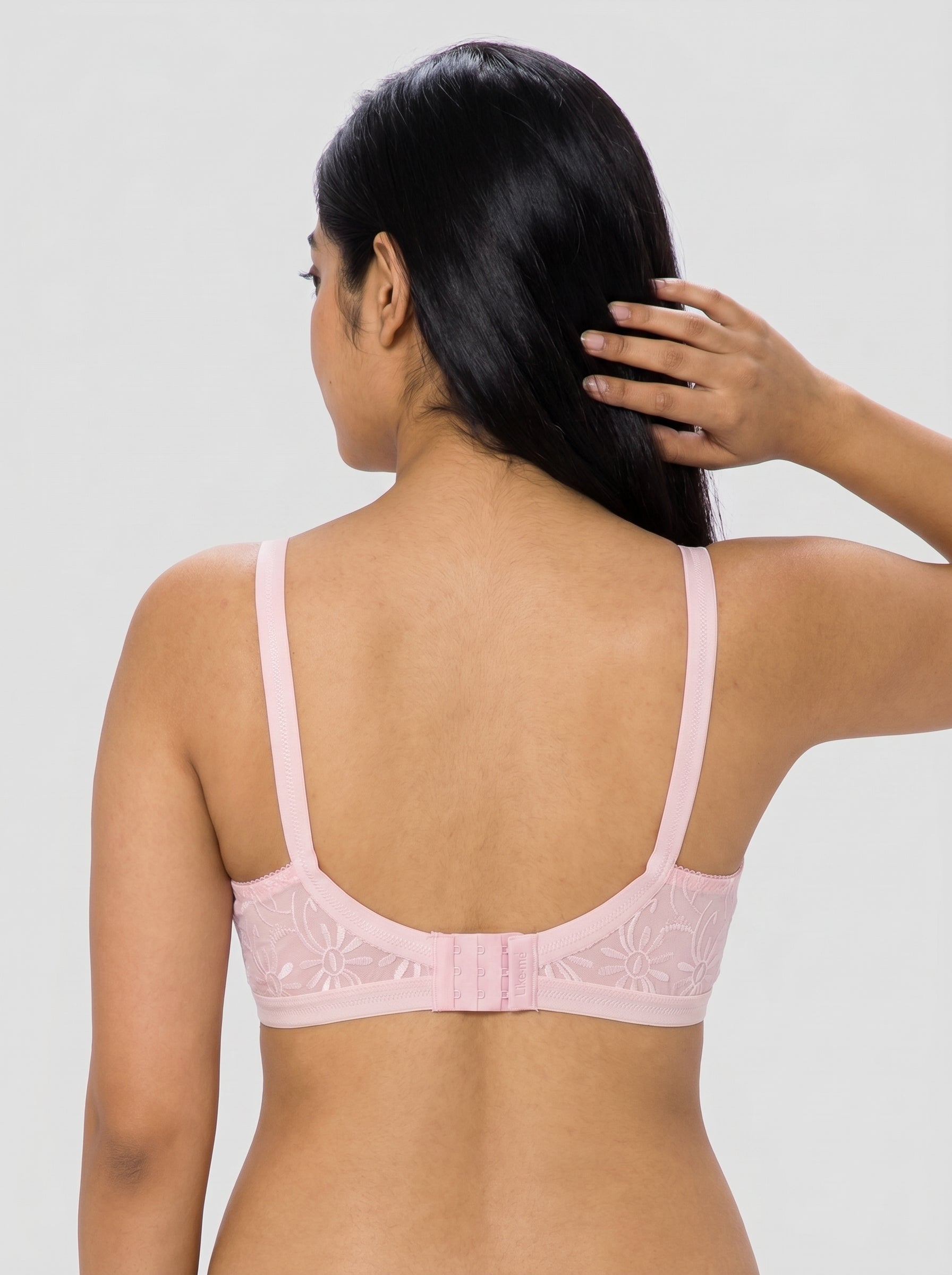 Woman wearing a pink bralette against a plain background #color_pink