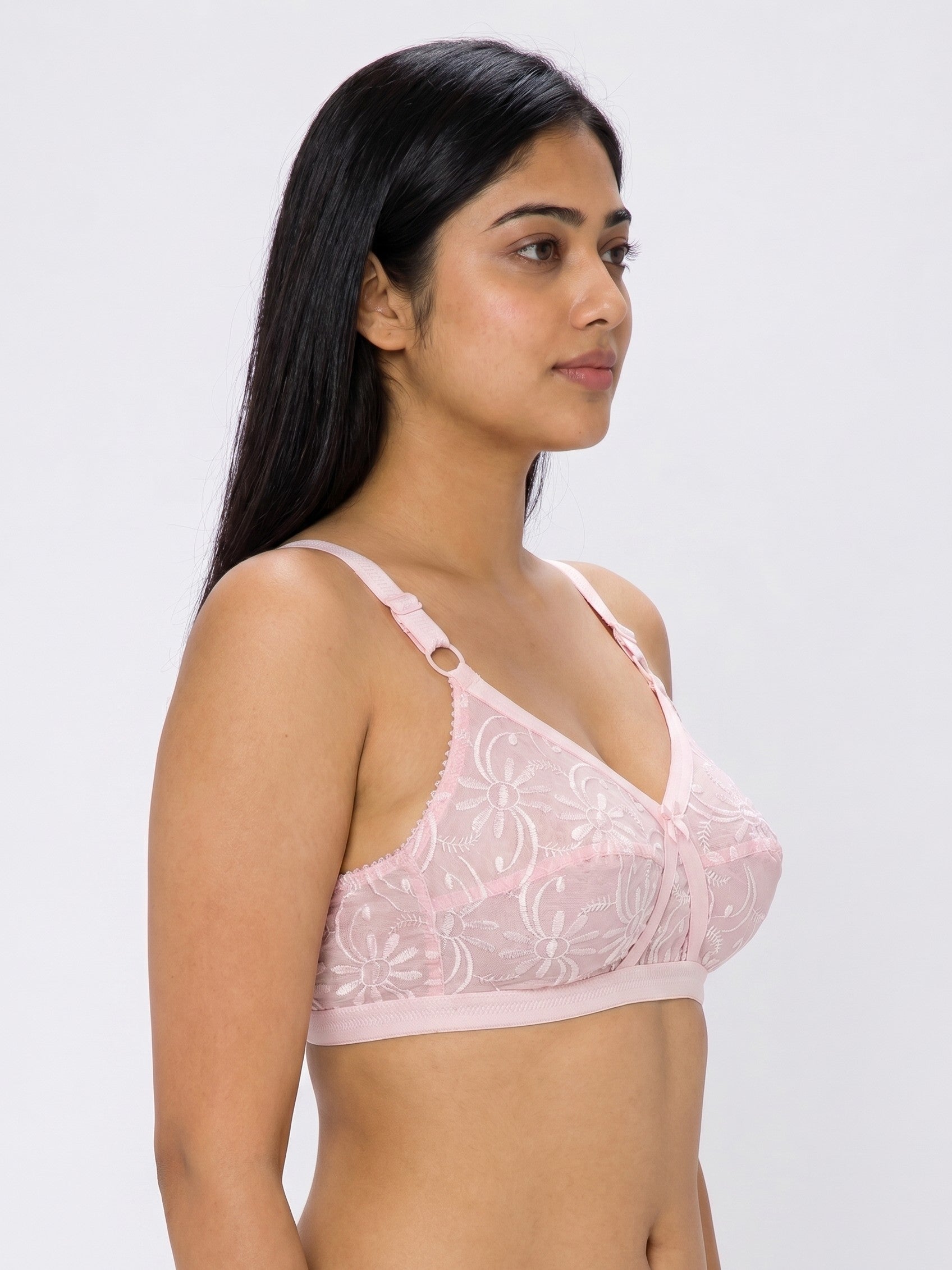 Woman wearing a pink lace bra against a white background #color_pink