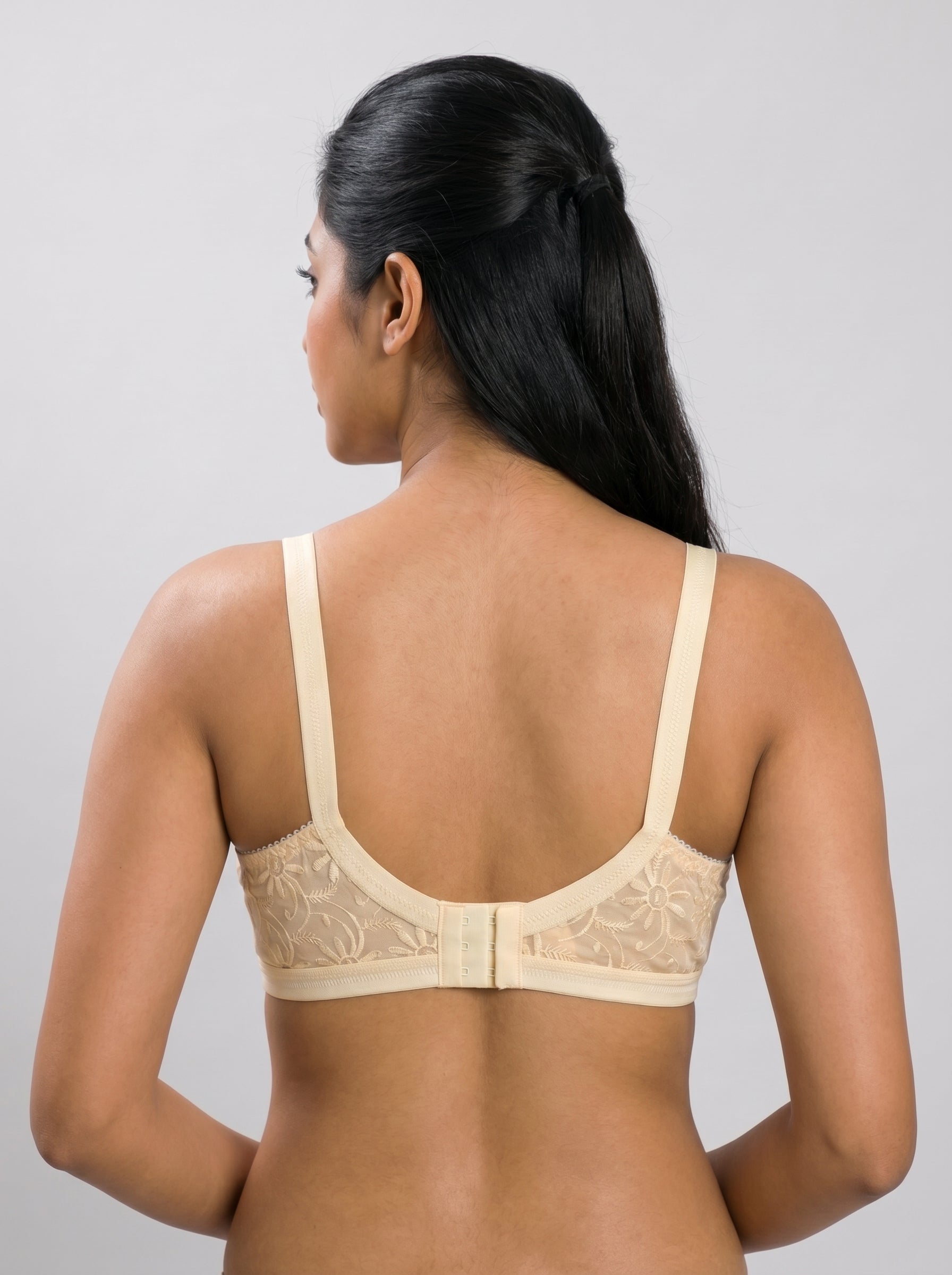 Woman wearing a beige bra against a gray background #color_skin