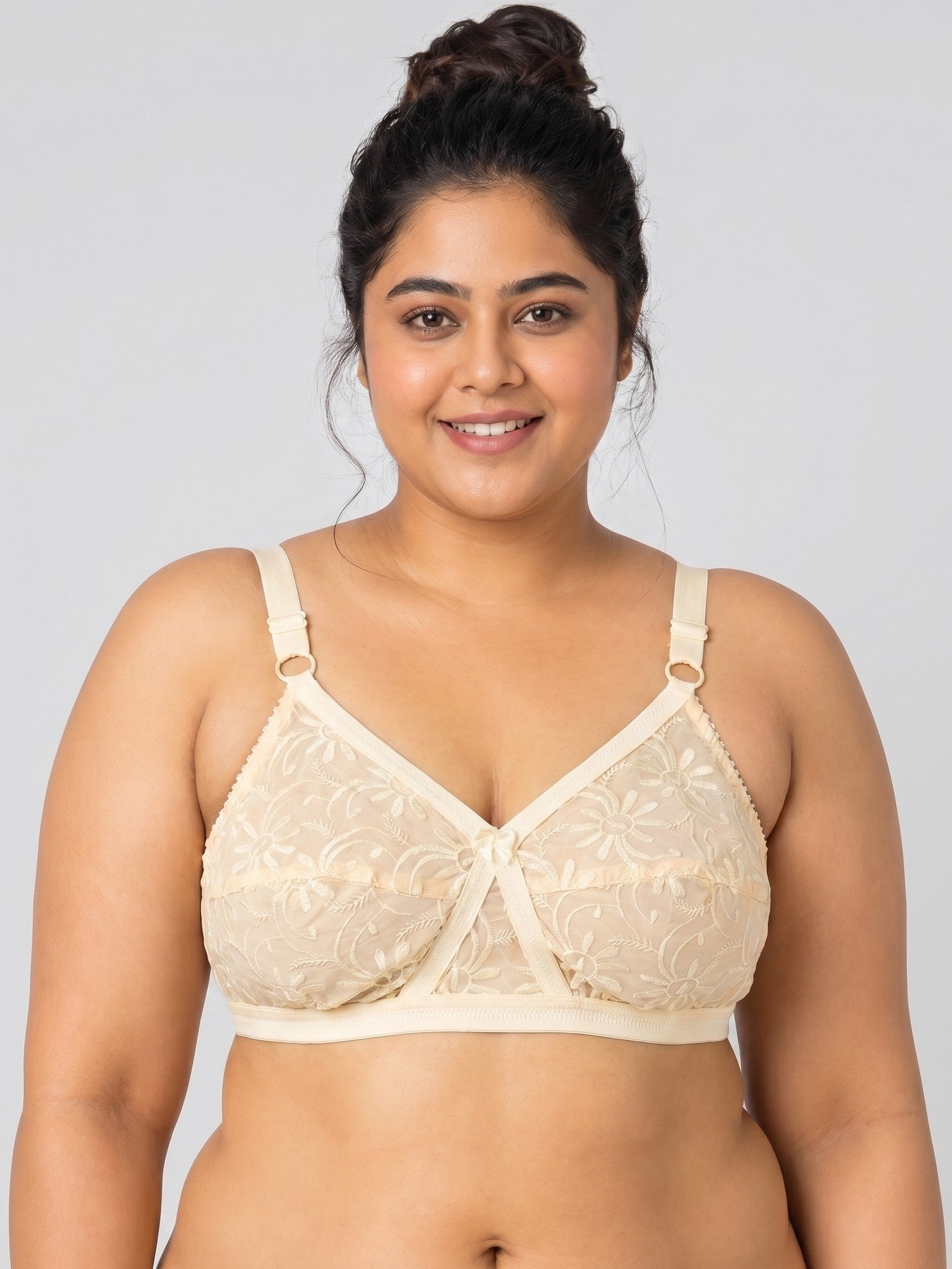 Woman wearing a beige bra against a plain background #color_skin