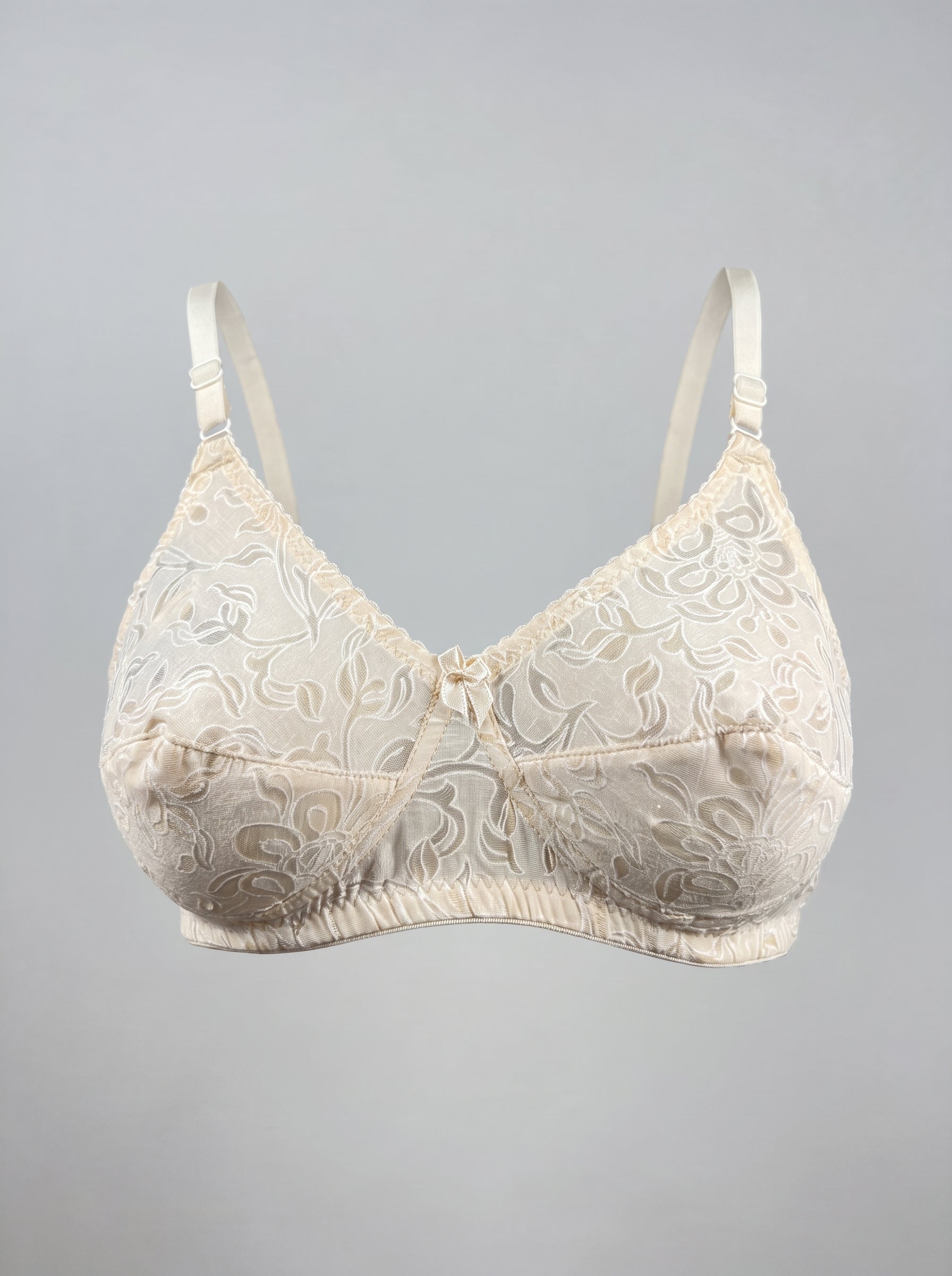 Skin Like-Me Eves Bra ghost mannequin front with soft cups and floral embroidery. #color_skin