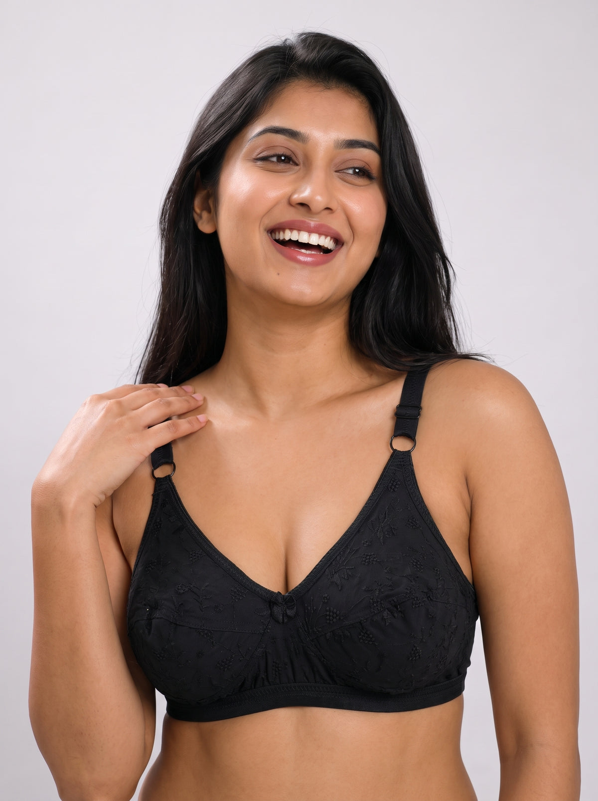 Like-Me Sonu Bra in black with floral lace cups, center bow and adjustable straps, front view on model. #color_black