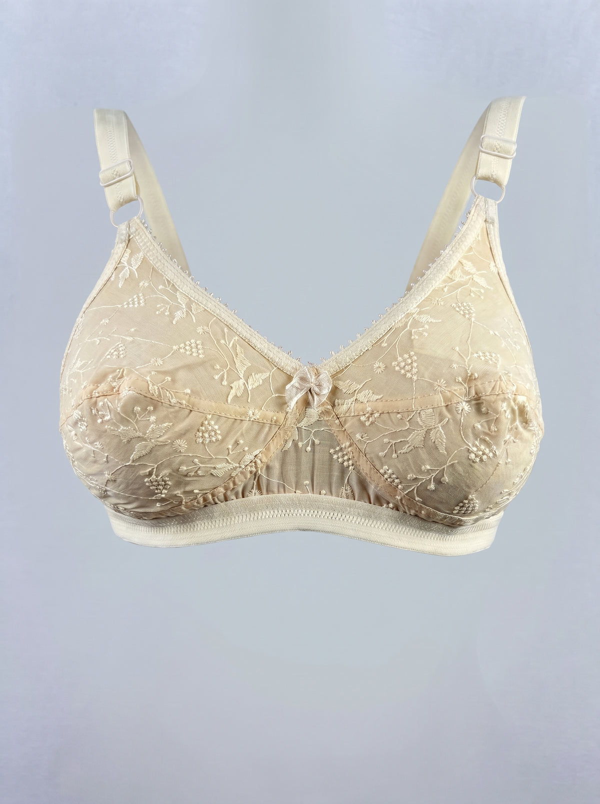 Like-Me Sonu Bra in skin color with floral lace cups, center bow and adjustable straps, ghost mannequin front view. #color_skin