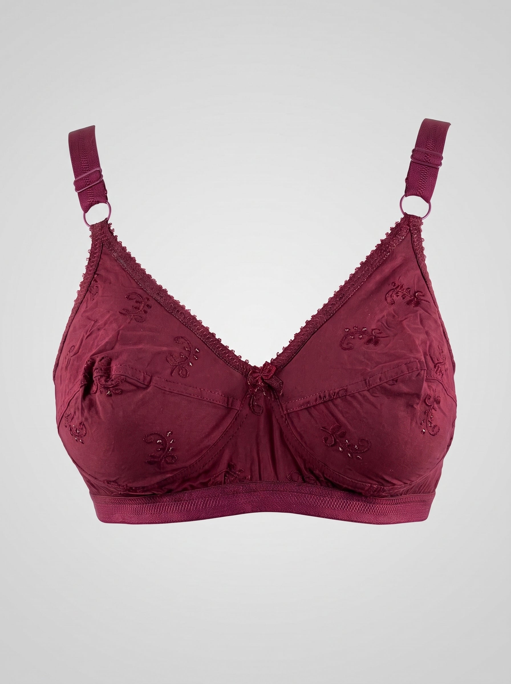 A burgundy underwire bra with decorative floral embroidery on the cups, scalloped edges, and adjustable shoulder straps with metal rings, shown against a light gray background. #color_maroon
