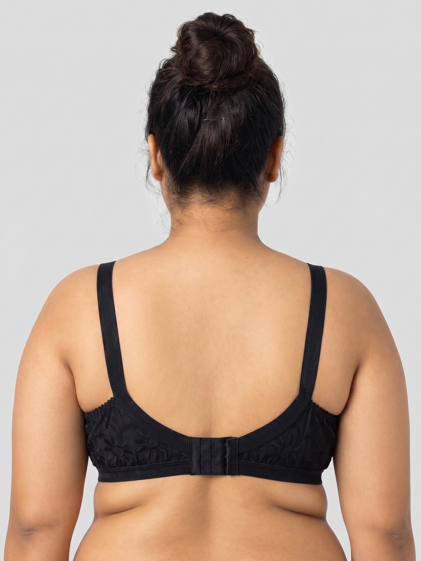 Person wearing a black bralette on a plain background #color_black