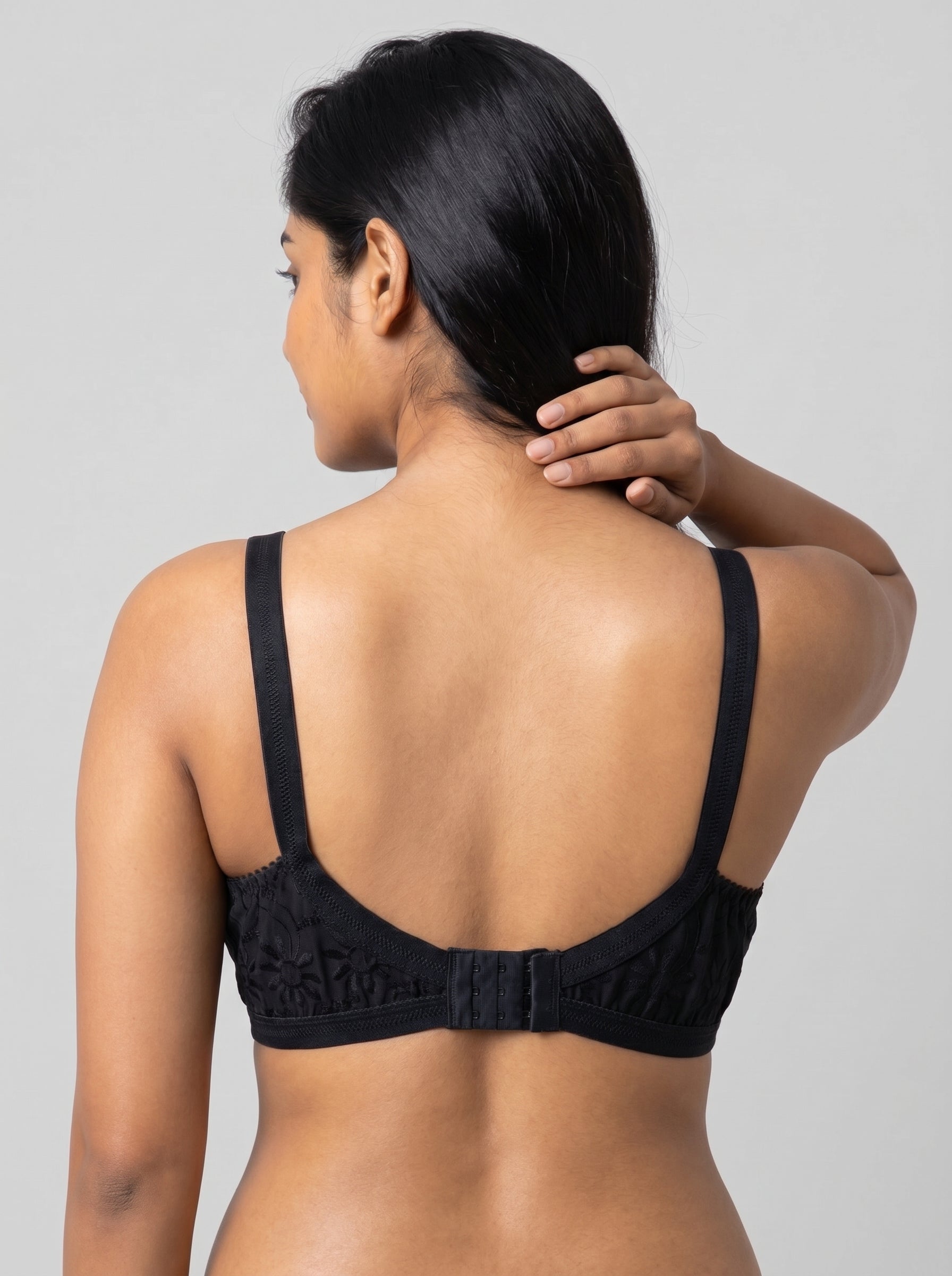 Woman wearing a black bralette against a gray background #color_black