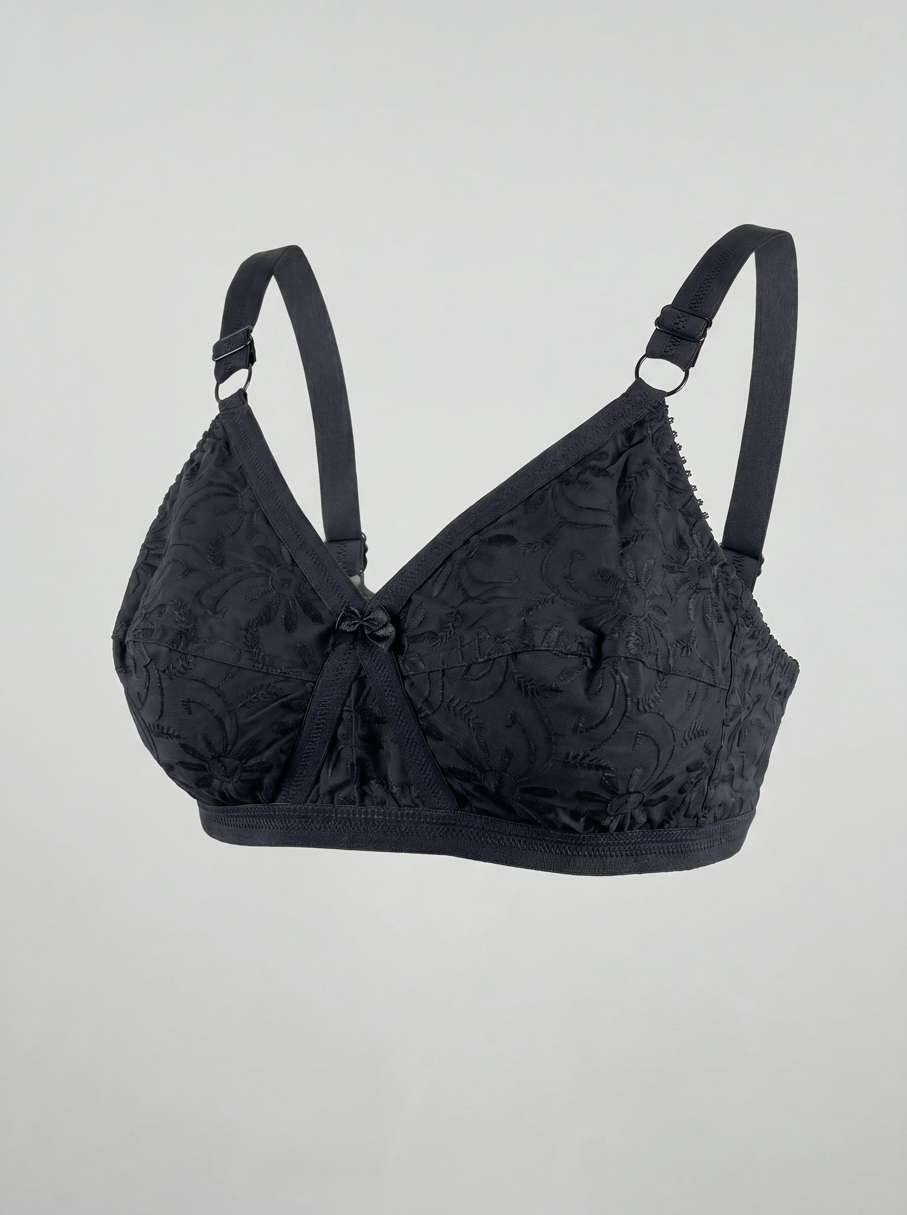 Black bra with floral lace details on a light gray background #color_black