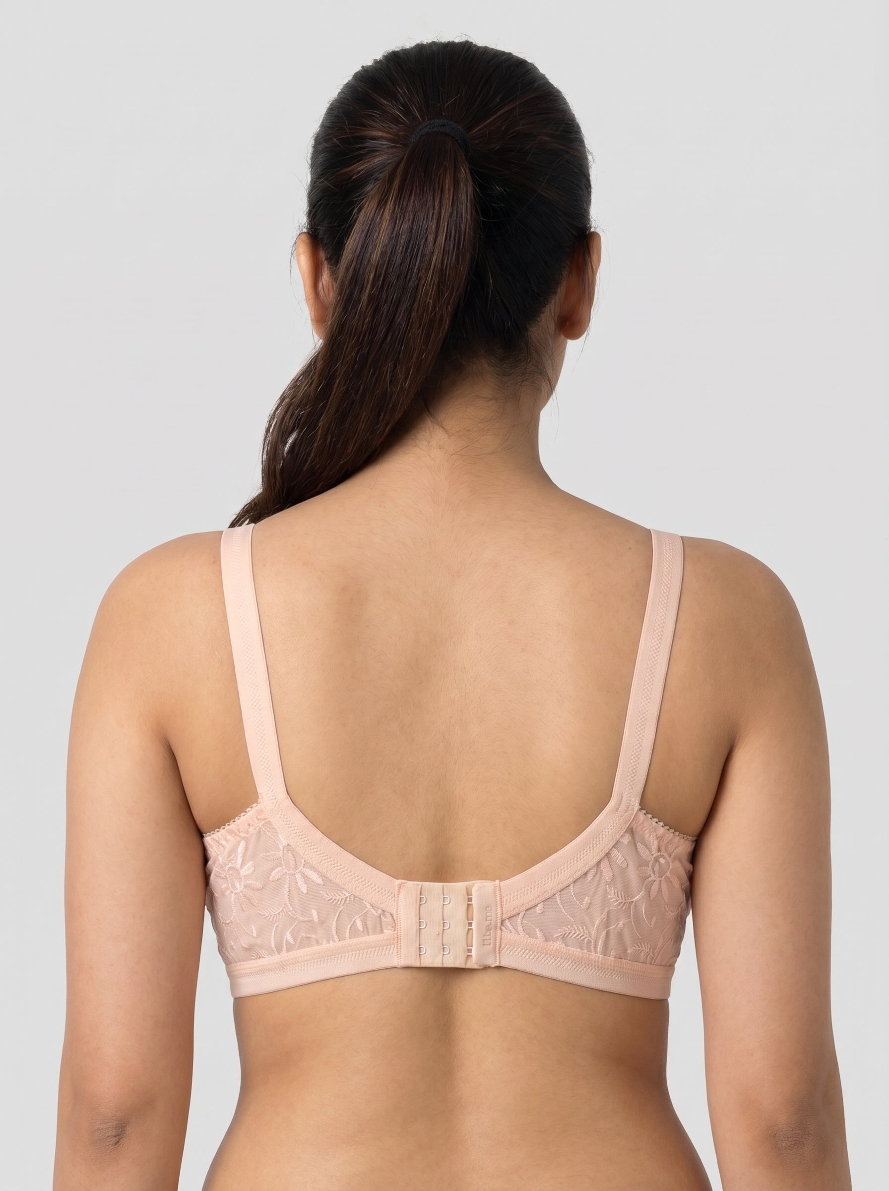 Woman wearing a beige bra against a plain background #color_peach