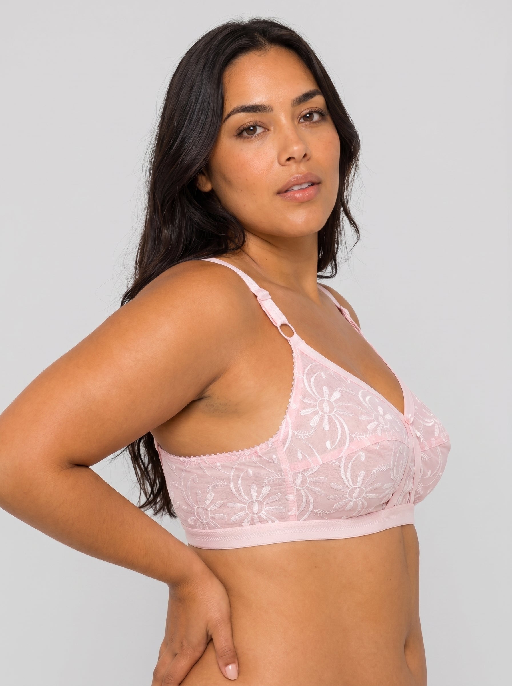 Woman wearing a pink lace bralette against a plain background #color_pink