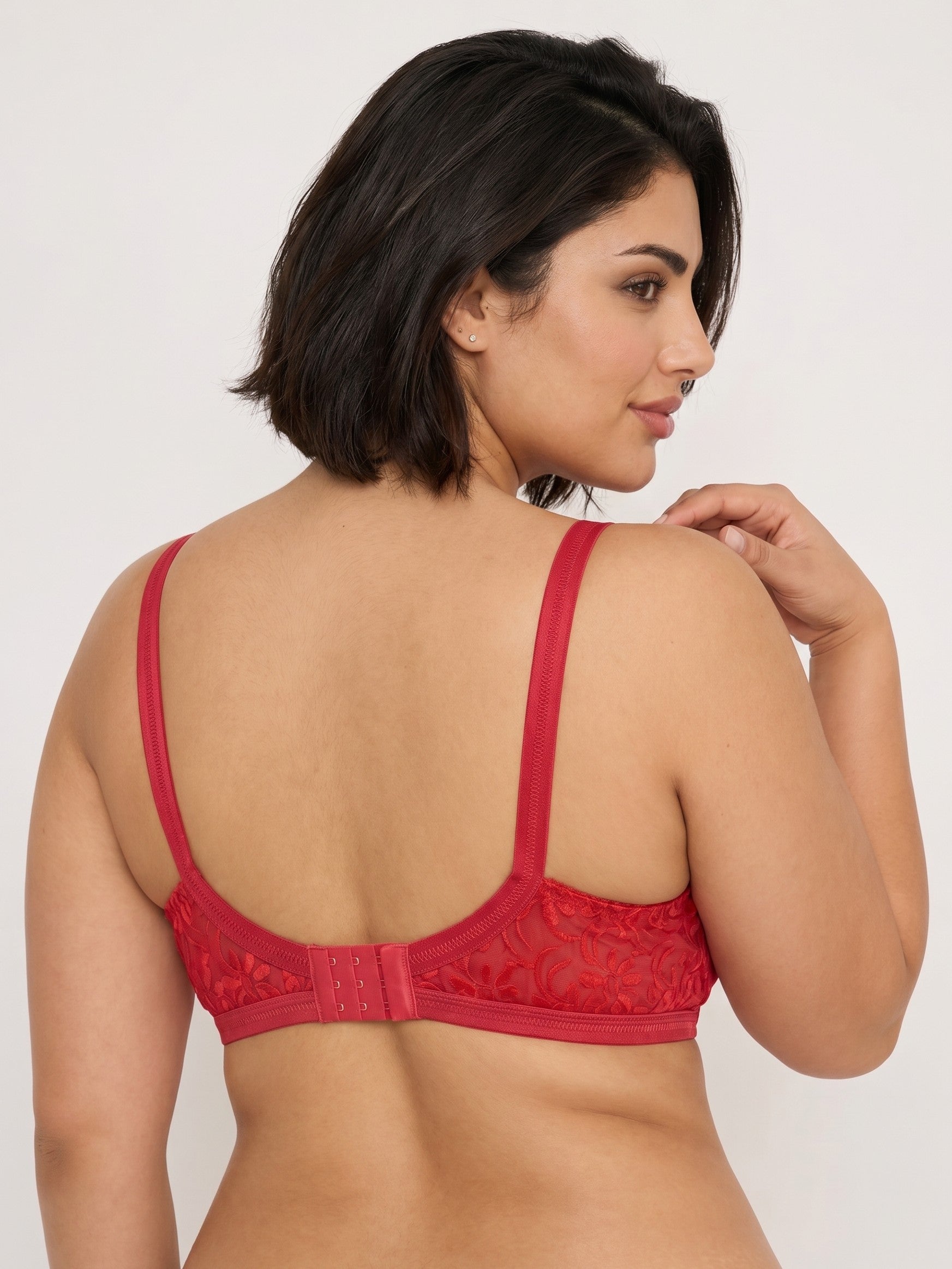 Woman wearing a red bralette against a plain background #color_red