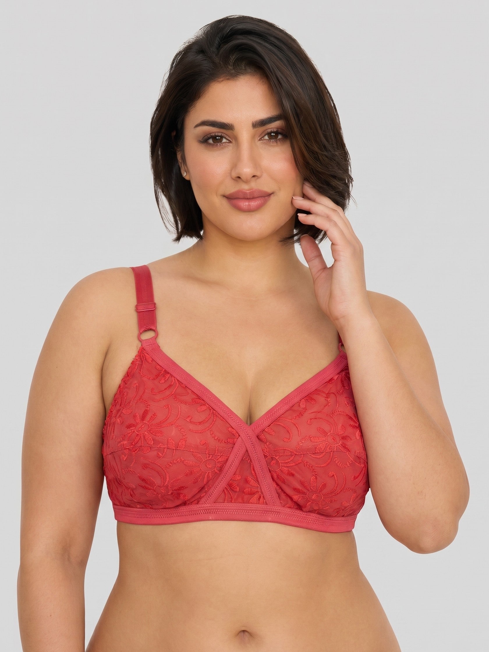Woman wearing a red lace bralette against a plain background #color_red