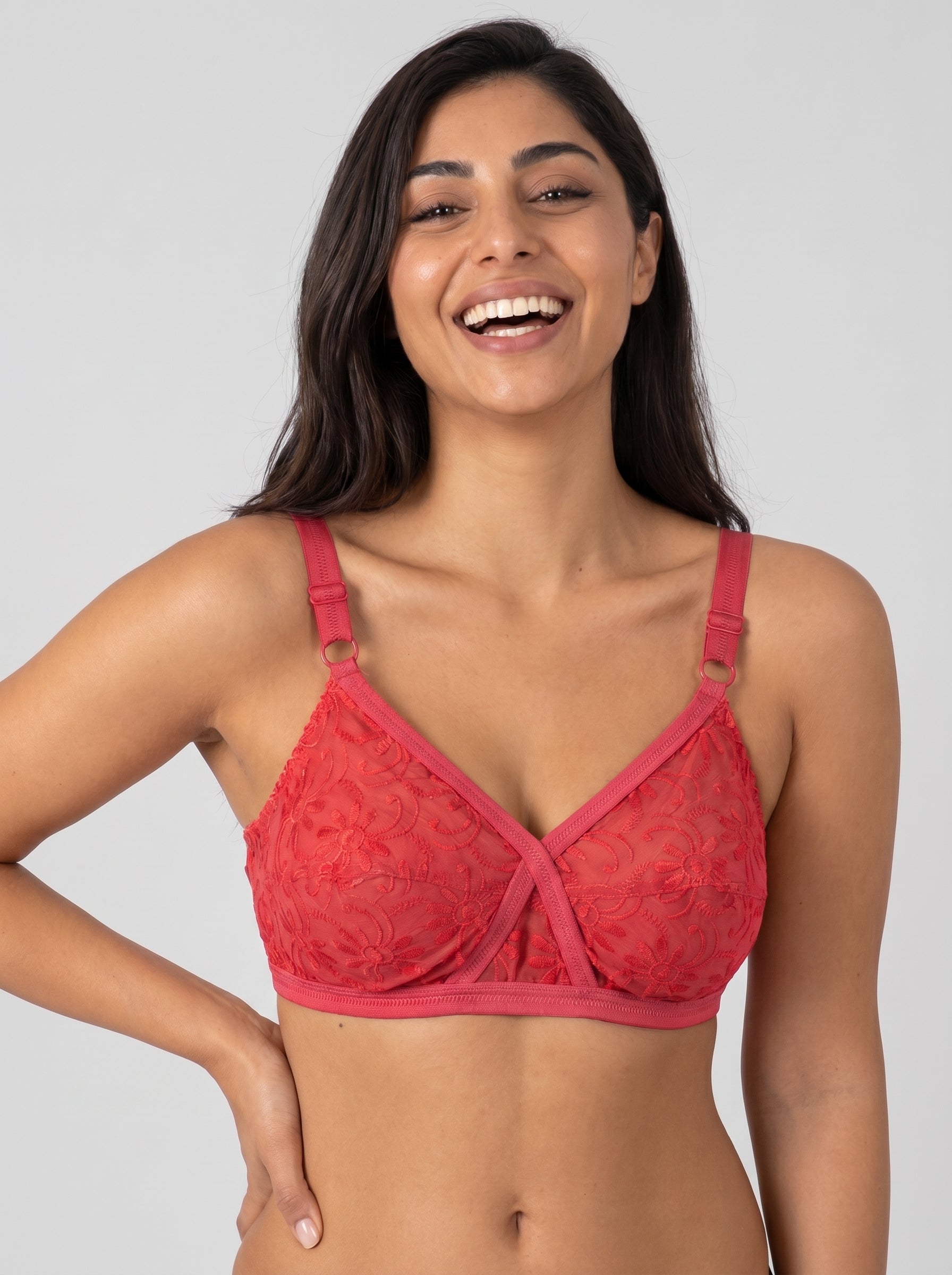 Woman wearing a red lace bra against a plain background #color_red