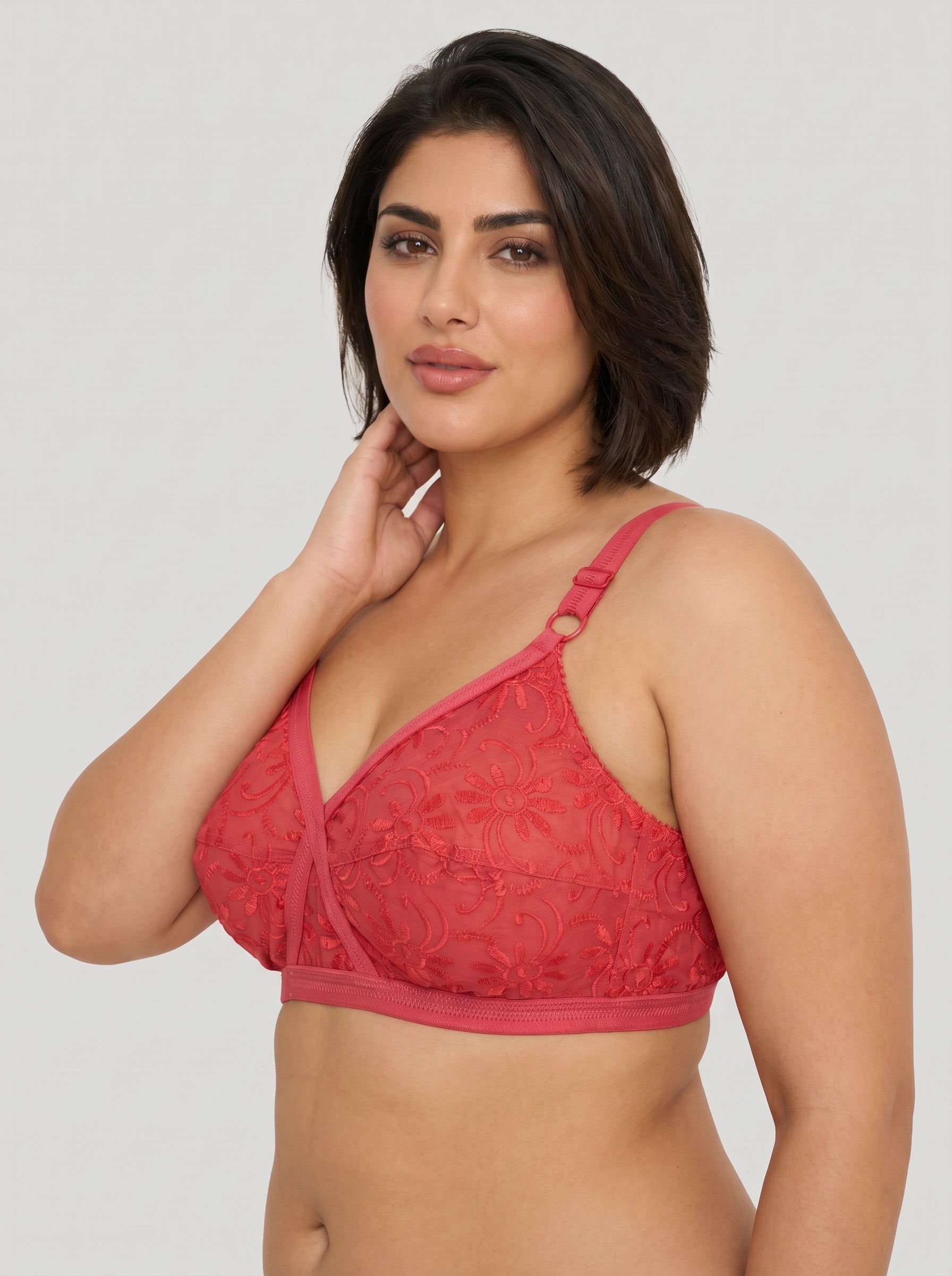 Woman wearing a red lace bralette against a plain background #color_red