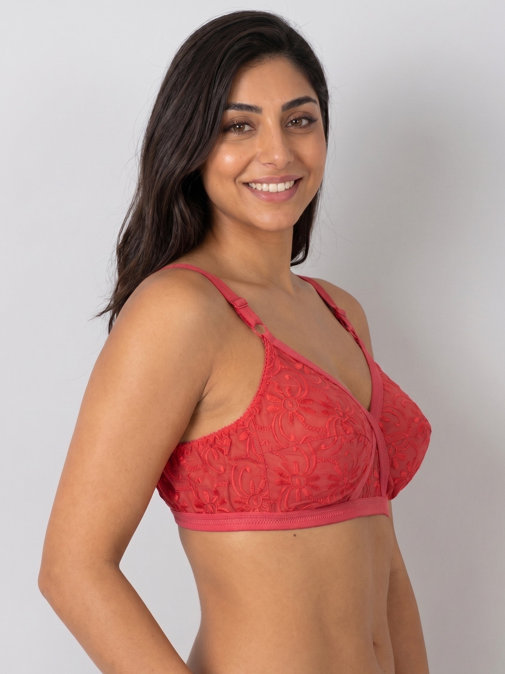 Woman wearing a red lace bralette against a plain background #color_red