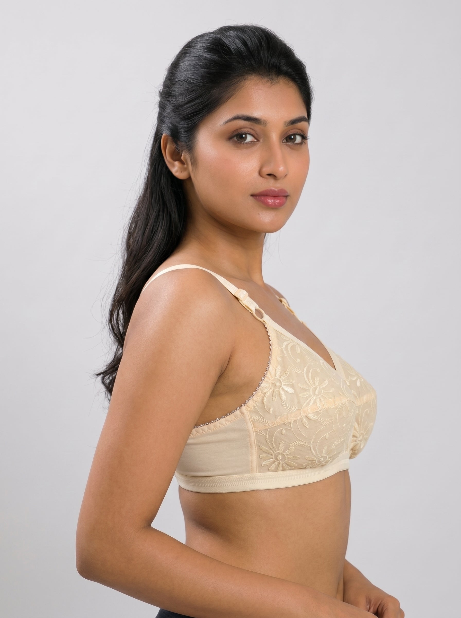 Woman wearing a beige bra against a plain background #color_skin