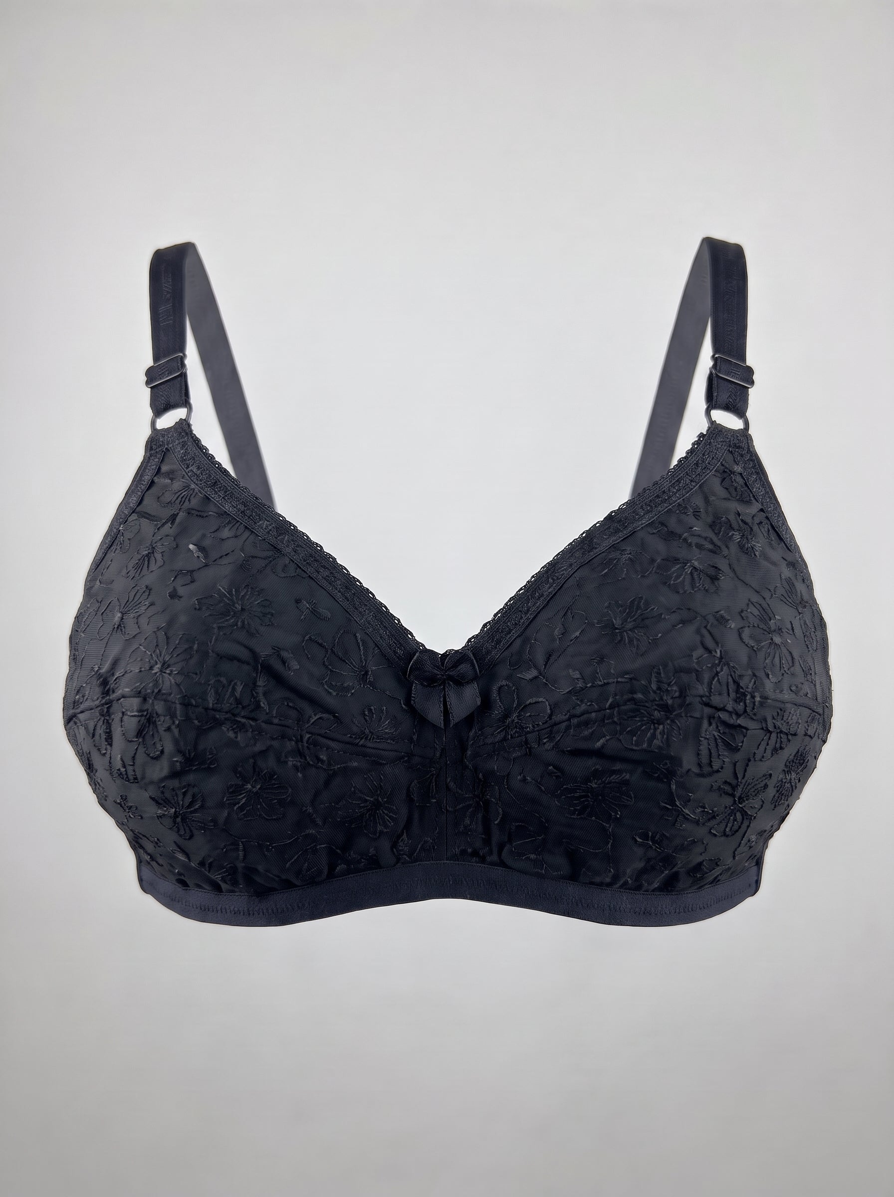 Black lace underwire bra with adjustable shoulder straps, shown against a plain light gray background. #color_black