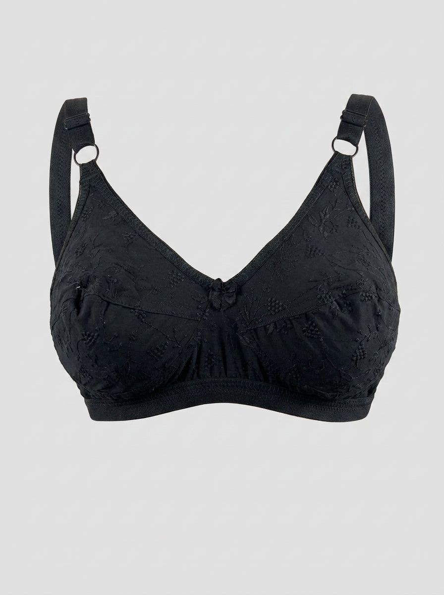 Like-Me Sonu Bra in black with floral lace cups, center bow and adjustable straps, ghost mannequin front view. #color_black