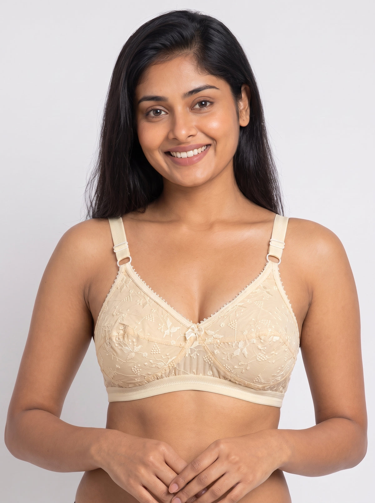 Like-Me Sonu Bra in skin color with floral lace cups, center bow and adjustable straps, front view on model. #color_skin